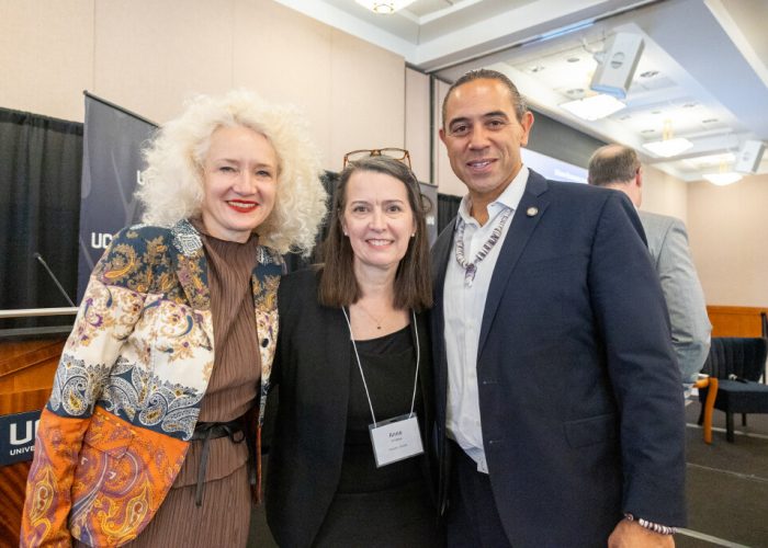 uconn president smiles for a photo with the economic forum guest speakers